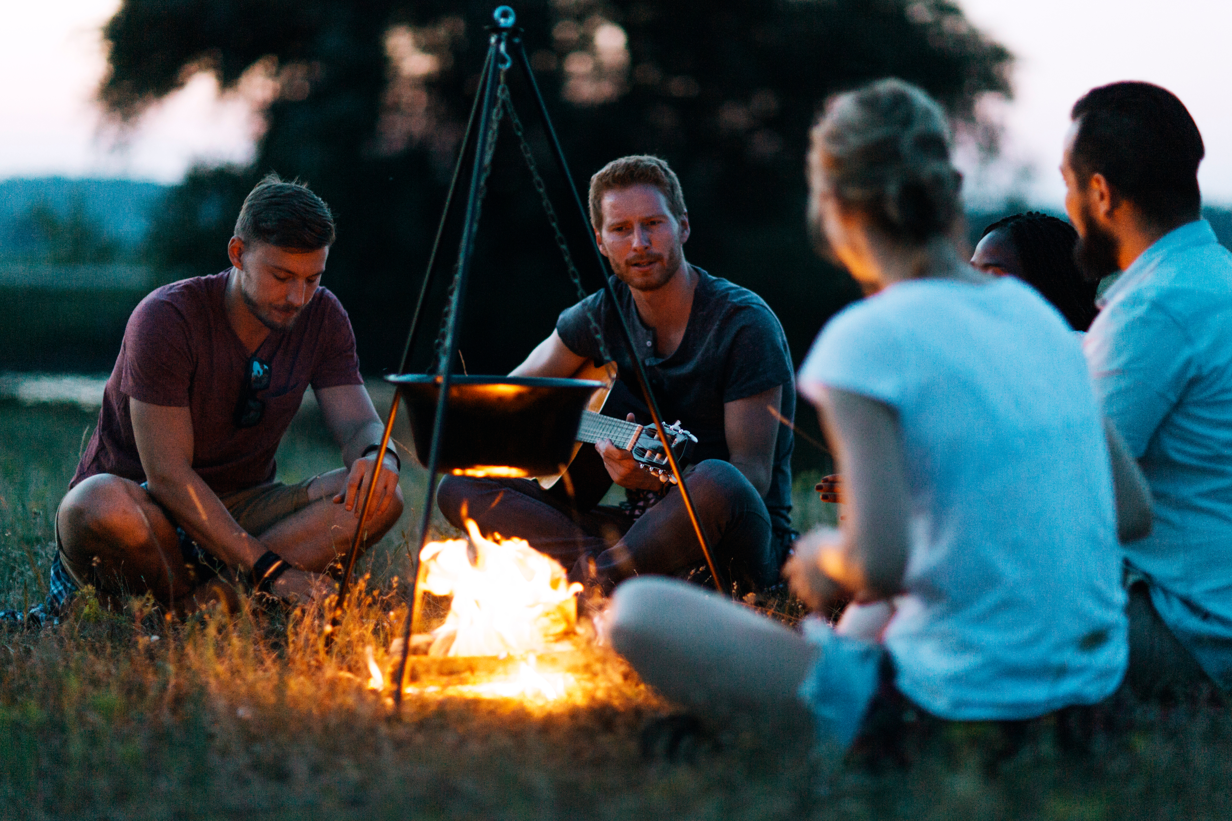 Friends sharing a moment around the fire while camping